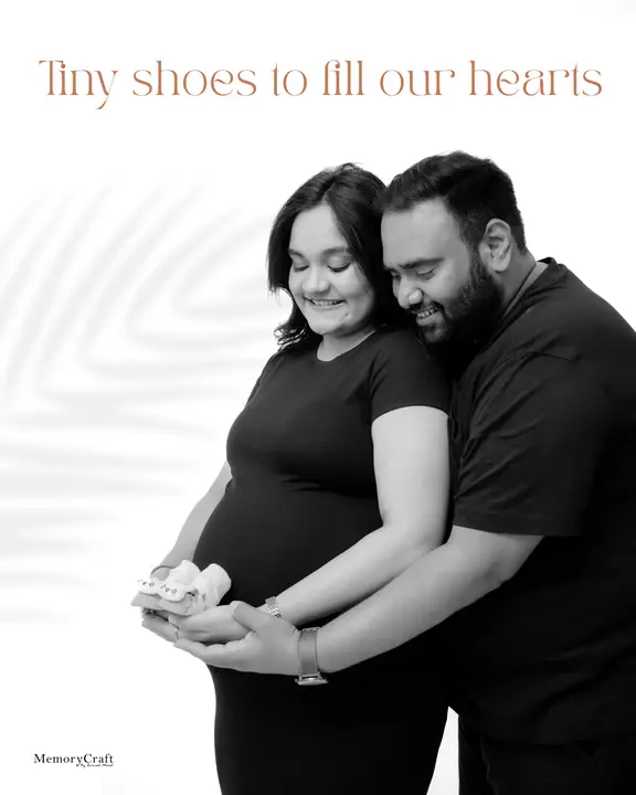 Akshay and Prachi: Holding the baby shoes.