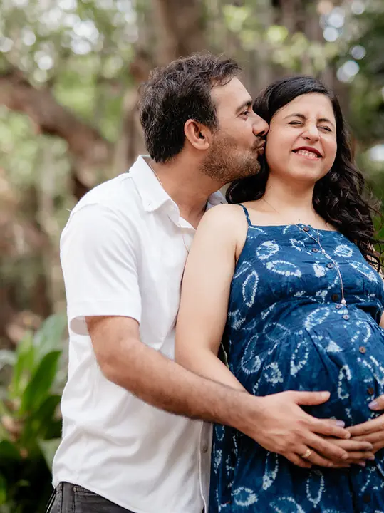 Pallavi and Hitesh share a happy moment in their outdoor maternity portrait.