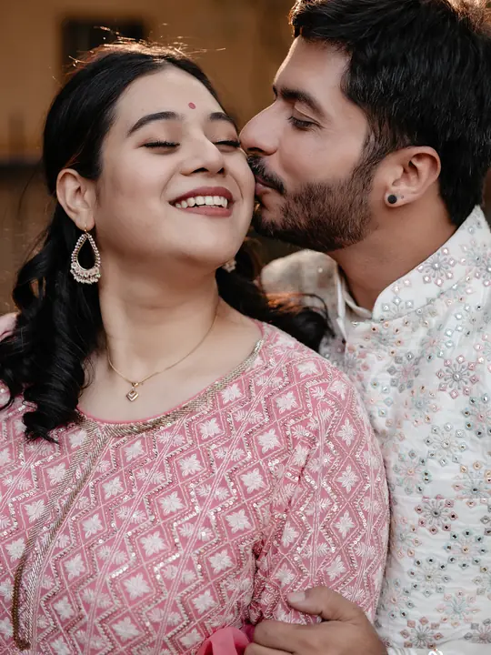 Tushar kisses Wipada on the cheek during their intimate wedding celebration.